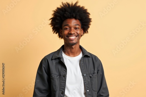 A Young Black Man with Natural Hair Smiling Against a Yellow Background: Capturing Joy and Confidence in a Studio Portrait photo