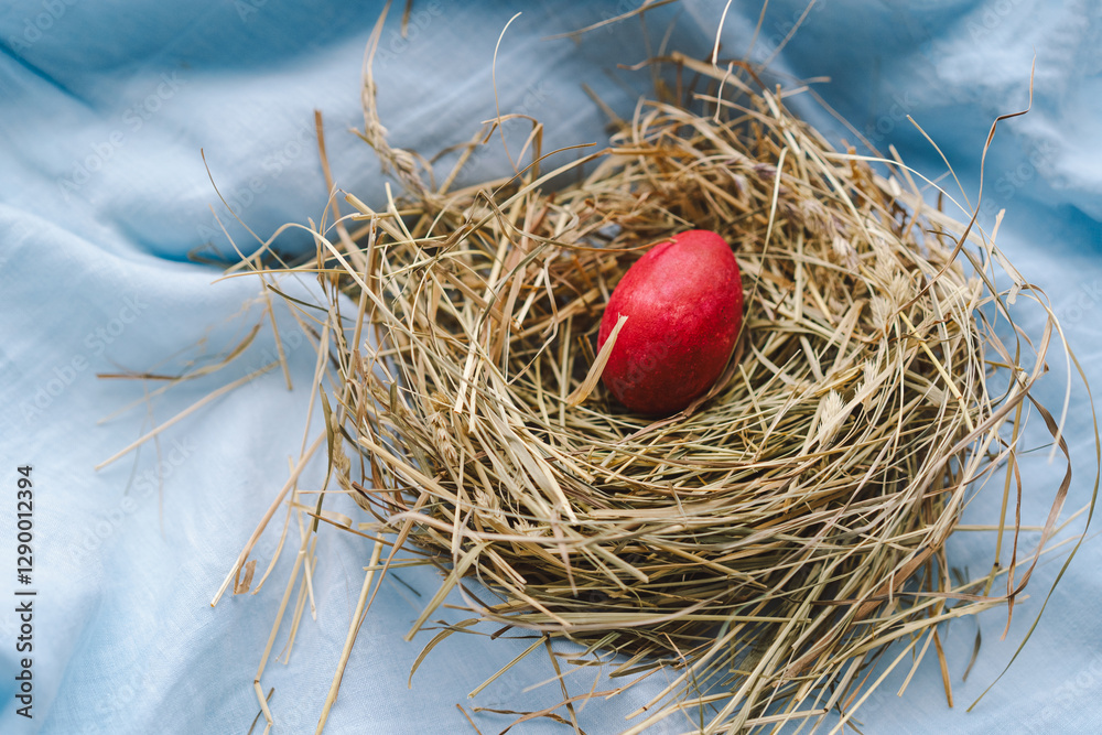 Vibrant Easter eggs are arranged in a cozy nest made of straw, with cheerful flowers contrasting against a soft blue backdrop. This scene captures the festive spirit of spring and Easter concept Vibrant Easter eggs are arranged in a cozy nest made of straw, with cheerful flowers contrasting against a soft blue backdrop. This scene captures the festive spirit of spring and Easter concept