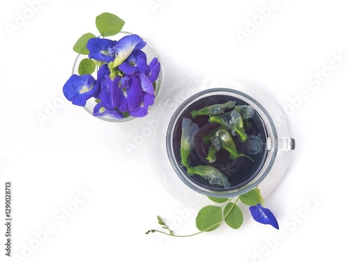 Boiled butterfly pea flower water in a glass on white background. Healthy herbal drink, Flat lay 
