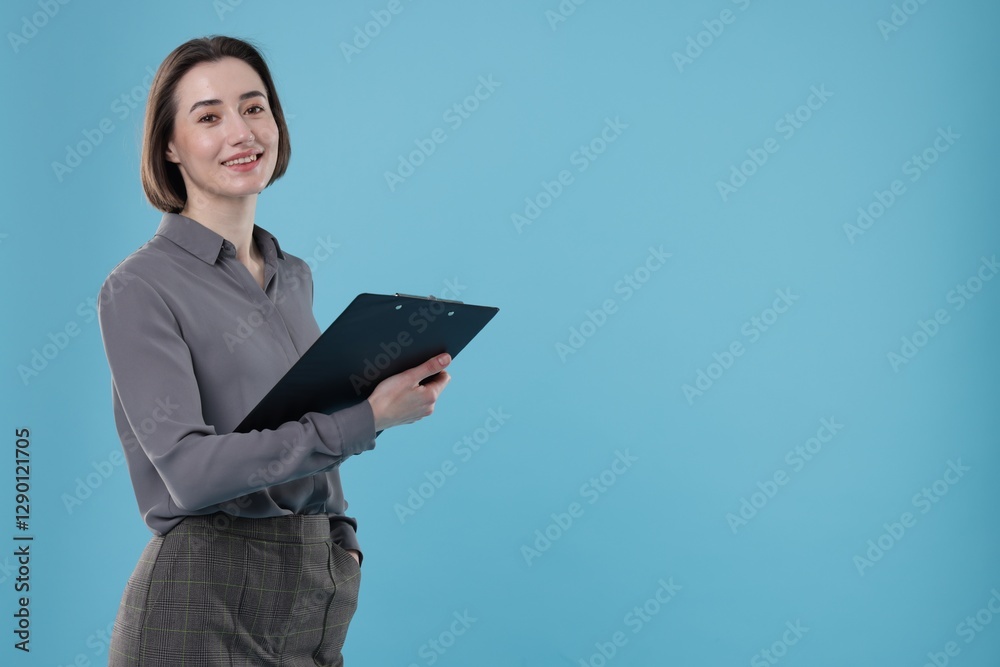 Portrait of smiling secretary with clipboard on light blue background. Space for text Portrait of smiling secretary with clipboard on light blue background. Space for text