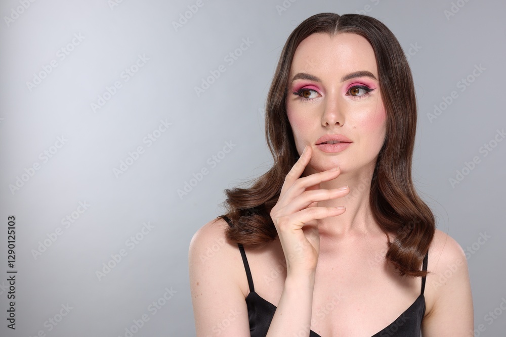 Portrait of beautiful young woman with stylish makeup and gorgeous hair on light grey background. Space for text Portrait of beautiful young woman with stylish makeup and gorgeous hair on light grey background. Space for text