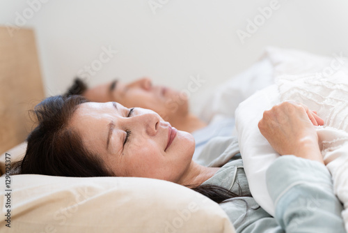 ベッドの上で眠る夫婦