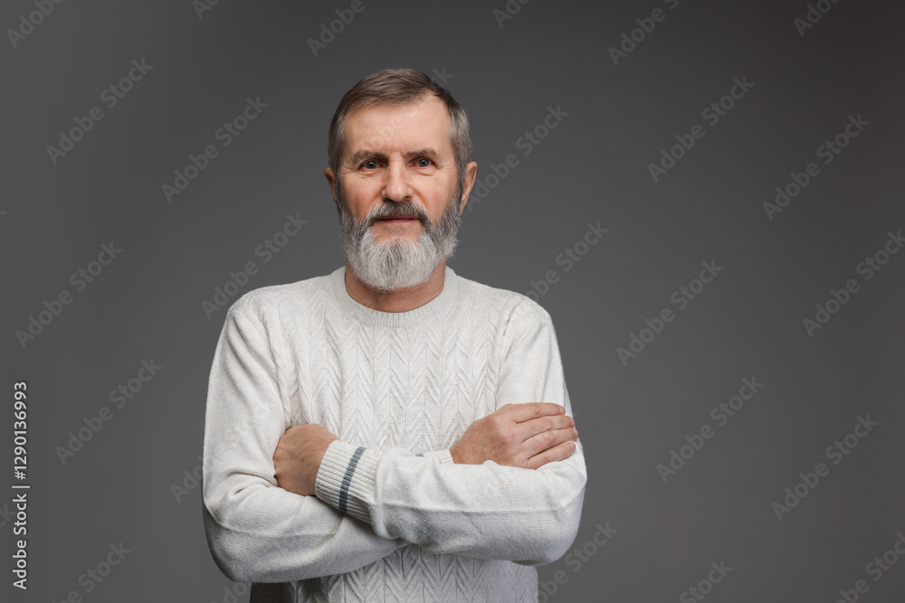 Portrait of mature man with crossed arms on grey background Portrait of mature man with crossed arms on grey background