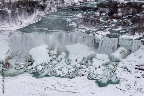 Niagara River and American Falls in turquoise color. Frozen waterfall.