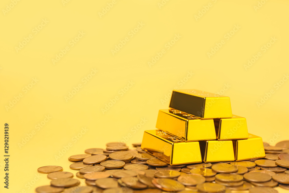 Gold bars and coins on pale yellow background, closeup. Space for text Gold bars and coins on pale yellow background, closeup. Space for text