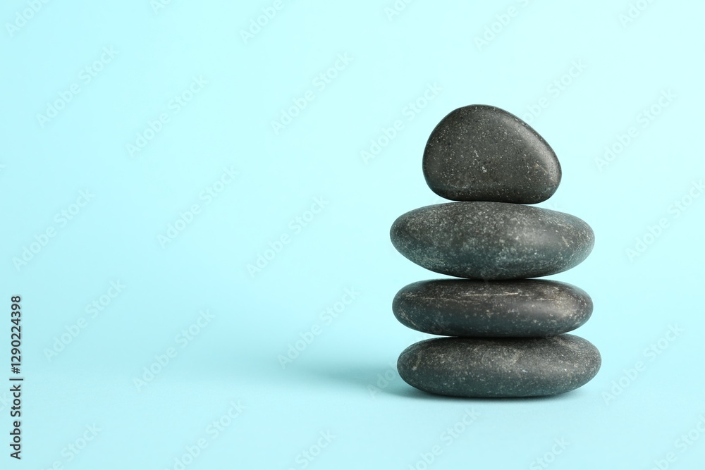 Stack of rocks on light blue background, space for text. Harmony and life balance Stack of rocks on light blue background, space for text. Harmony and life balance
