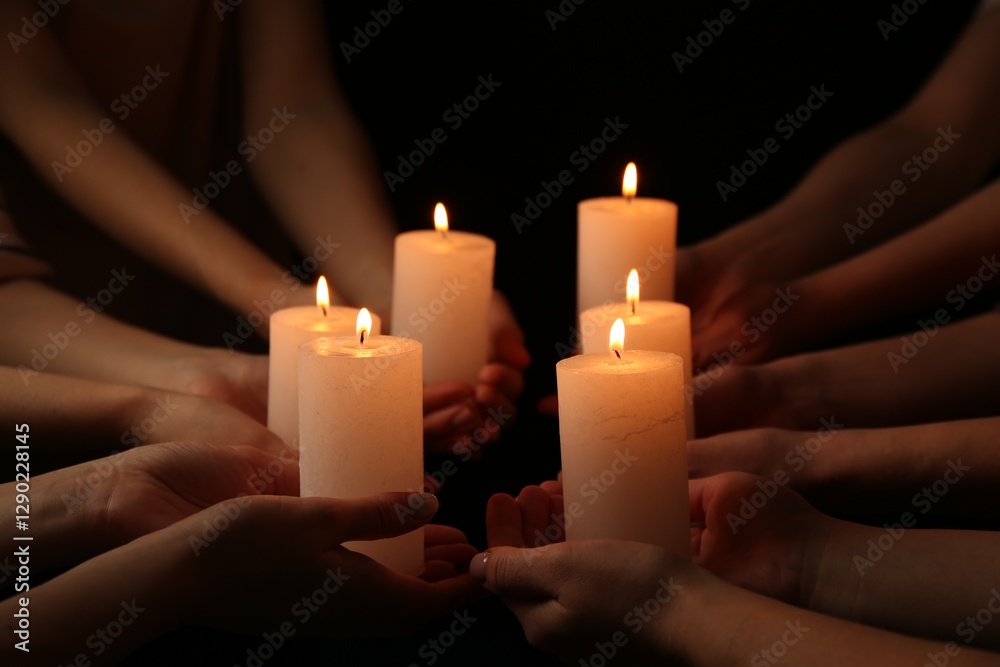 Women with burning candles on dark background, closeup Women with burning candles on dark background, closeup