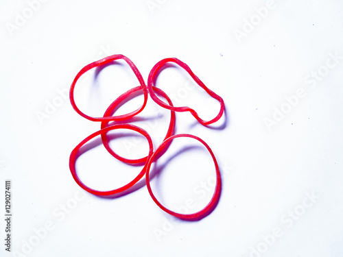 Obraz na plátně Close-up red rubber bands against a plain white background