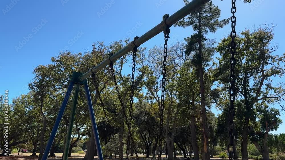 Chains on a swing swinging as the swing swings, in a park in Cape Town. Chains on a swing swinging as the swing swings, in a park in Cape Town.