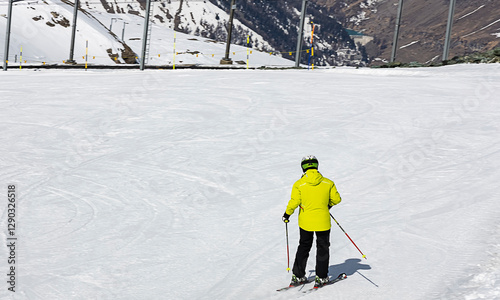 Skier man in action as going downhill on ski trail slope piste in winter mountain