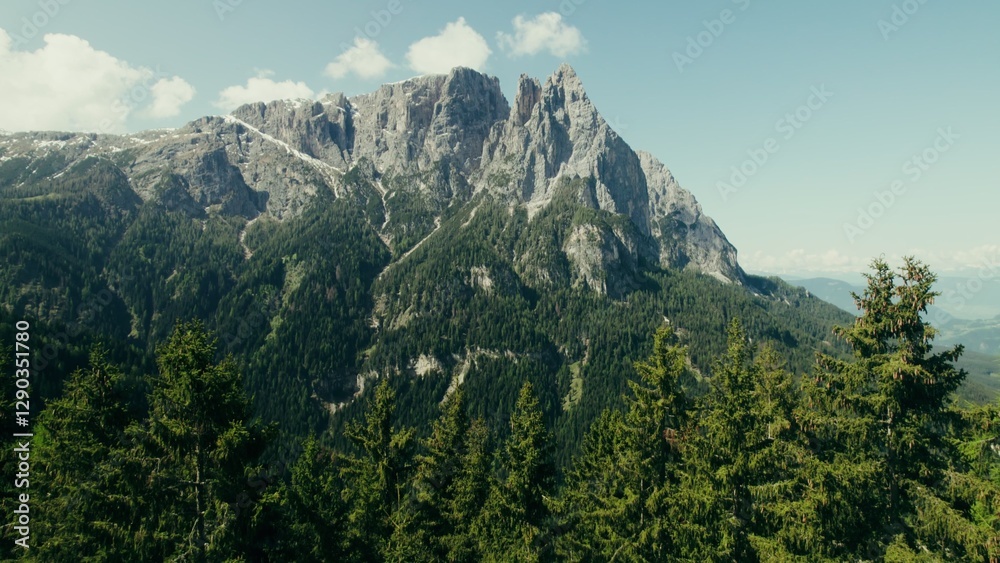 Fototapeta premium Drone view of a high-altitude valley with rocky peaks and slopes overgrown with spruce forest