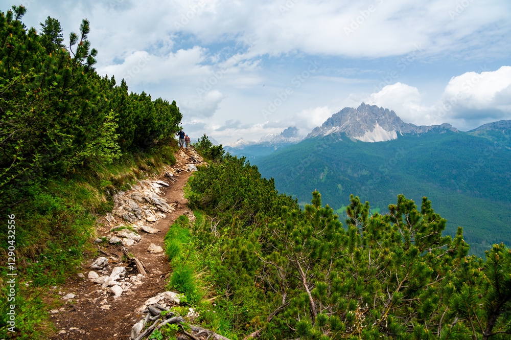 Breathtaking view of forests, mountains, and valleys in the Italian Dolomites (Dolomiti, Dolomiten). Captured from a scenic trail along a rocky ledge. Stunning alpine nature