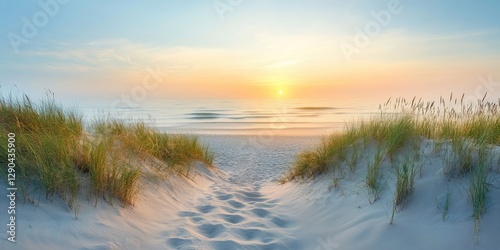 Fototapeta Naklejka Na Ścianę i Meble -  Serene sunrise over a calm Baltic Sea with golden and blue hues, sandy beach framed by lush green grass, perfect for tranquil backdrop designs.