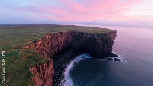 Dramatic coastal cliff sunrise, ocean waves, green plateau