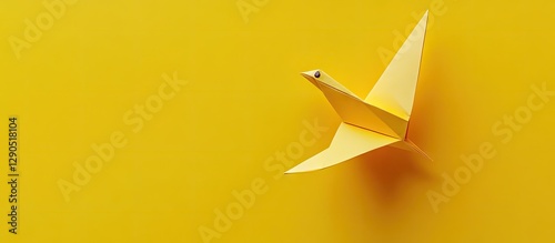 Yellow origami bird positioned on bright yellow background with soft shadows enhancing depth and space for text on the right side