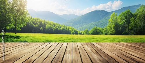 Wooden table foreground with blurred green meadow and mountains under a bright blue sky, sunlight illuminating a serene landscape.