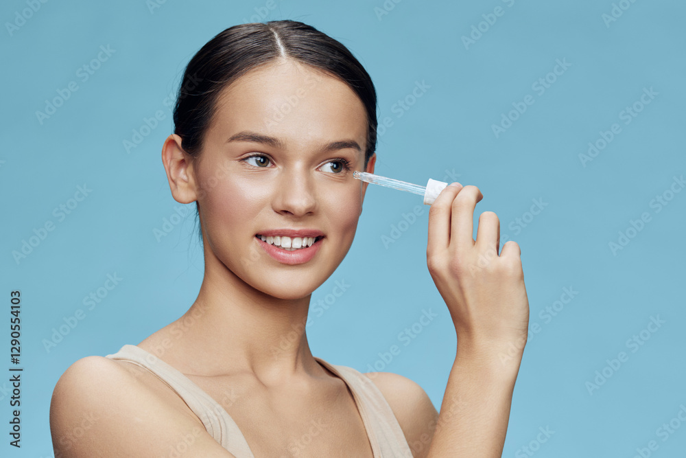 Young female model applying skincare serum with a dropper against a soft blue background, embodying fresh beauty and self care in a vibrant, serene atmosphere Young female model applying skincare serum with a dropper against a soft blue background, embodying fresh beauty and self care in a vibrant, serene atmosphere