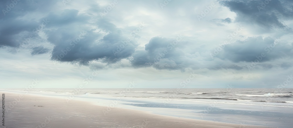 Serene beach landscape with grey clouds above, gentle waves lapping on sandy shore, soft muted tones of blue and grey creating a tranquil atmosphere. Serene beach landscape with grey clouds above, gentle waves lapping on sandy shore, soft muted tones of blue and grey creating a tranquil atmosphere.
