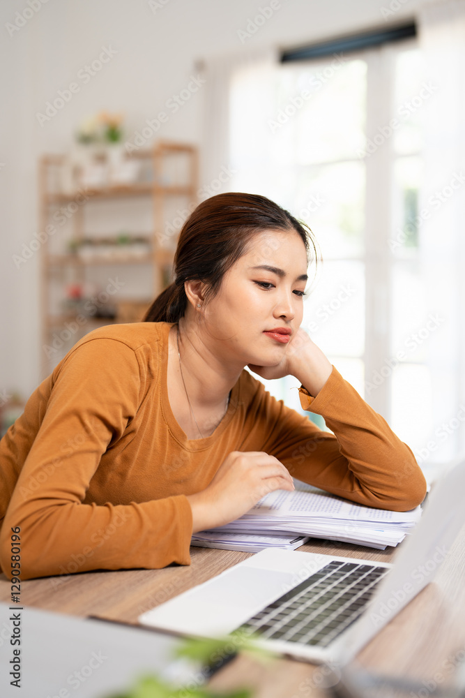Bored young asian female tired of working sit at home staring laptop screen, lazy business woman frustrated about computer work feeling uninterested demotivated .