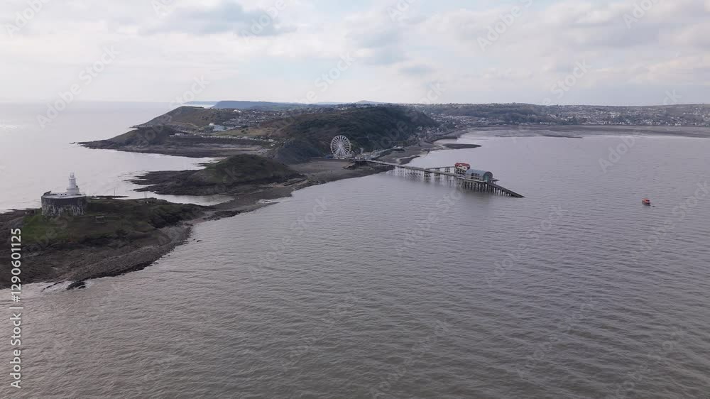 Aerial panoramic approach to the Big Wheel at Mumbles Pier, showing details of the structure and movement under cloudy sky