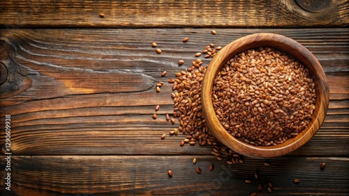 Top view of a wooden bowl filled with organic flaxseed on a rustic table