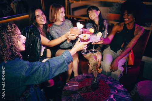 Group of friends toasting cocktails in a lively and stylish nightlife setting