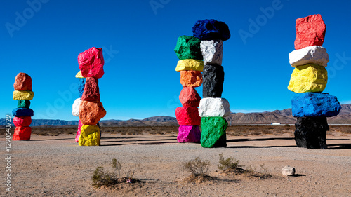 Vibrant and colorful rock sculptures create a whimsical contrast against the stark desert landscape, symbolizing creativity and artistic expression amidst nature.