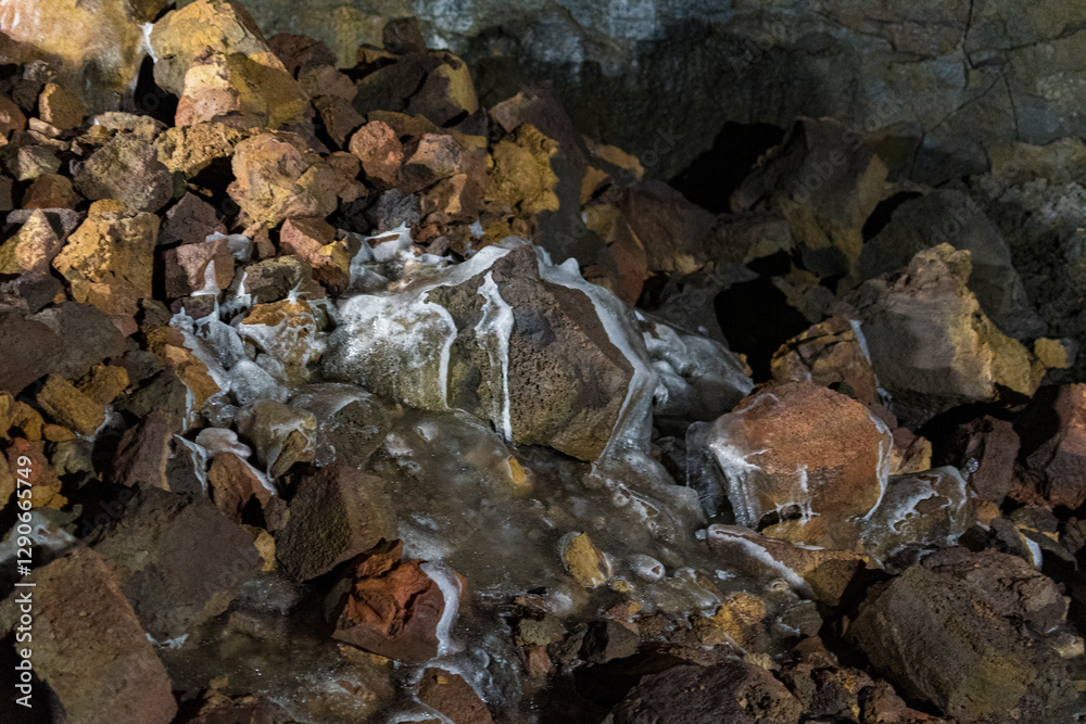 An intriguing close-up of a rocky floor featuring flowing water and vibrant mineral deposits, illustrating the dynamic processes of nature and geological beauty.