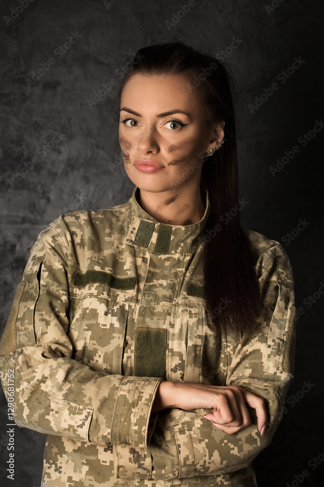 Beautiful young military woman in Ukrainian military uniform with camouflage makeup on her face