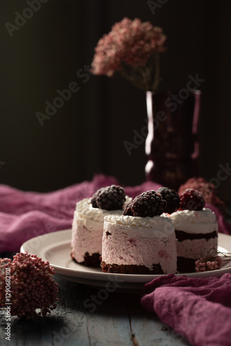 Obraz na płótnie Delicious cream cakes with frozen blackberries on a plate w salonie