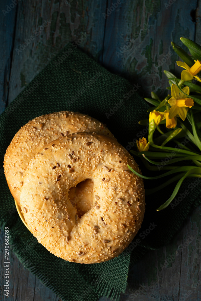 Still life in rustic style bagels sprinkled with seeds with daffodils