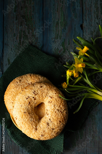 Obraz na płótnie Still life in rustic style bagels sprinkled with seeds with yellow daffodils w salonie