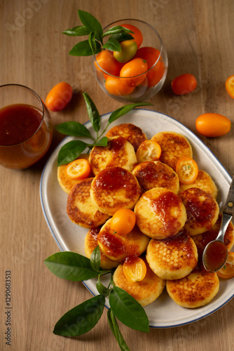 Delicious homemade pancakes with cottage cheese, kumquat jam and fruits on a table