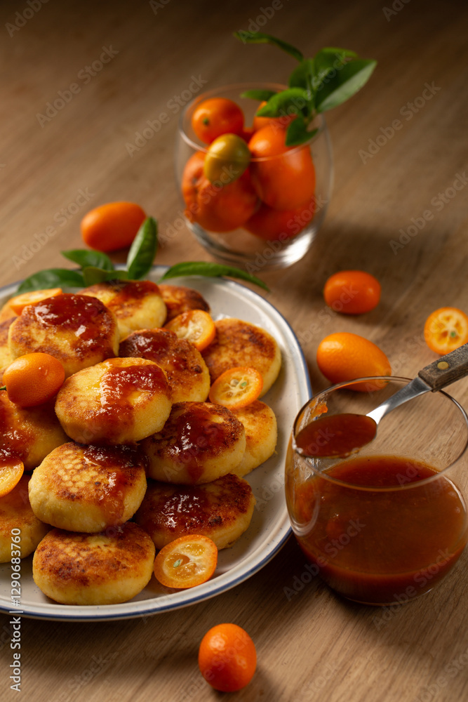 Homemade pancakes with cottage cheese, kumquat jam and fruits on a table