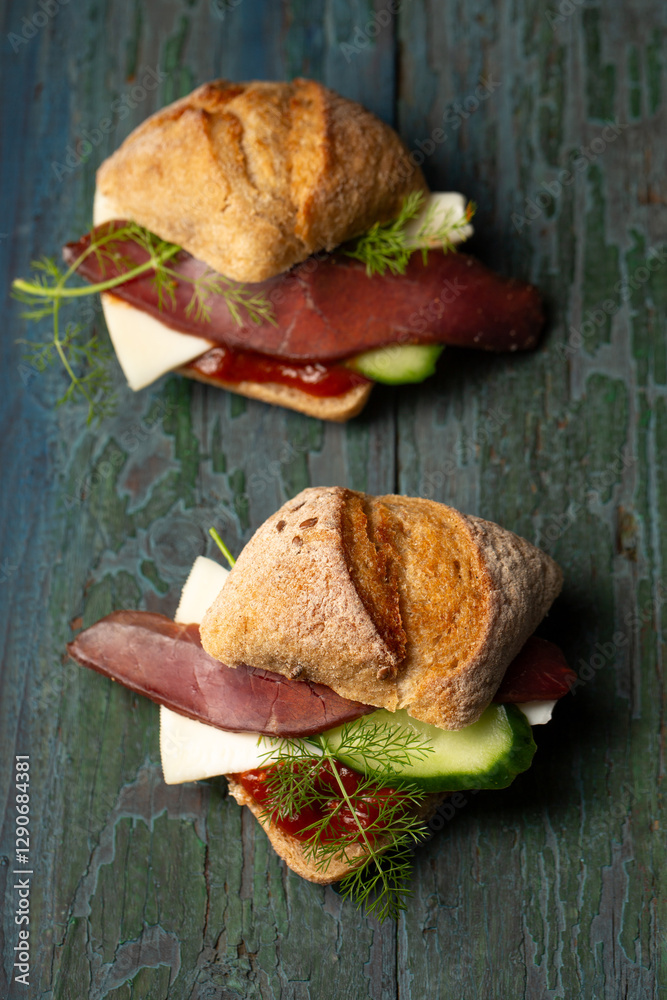 Two sandwiches with basturma, herbs and cucumber