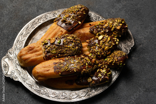 Chocolate and pistachio eclair cookies on a vintage plate