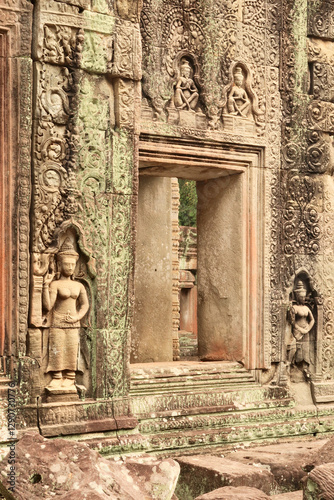 Apsaras, monks and ornaments are carved into the sandstone around a window inside the Prasat Preah Khan Temple, Angkor Wat, Siem Reap, Cambodia photo