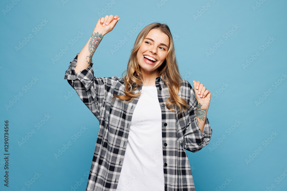 Fototapeta premium Young smiling woman she wears checkered grey shirt casual clothes doing winner gesture celebrate clenching fists dancing isolated on plain pastel light blue cyan background studio. Lifestyle concept.