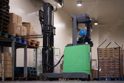 冷蔵倉庫でフォークリフトに乗る男性