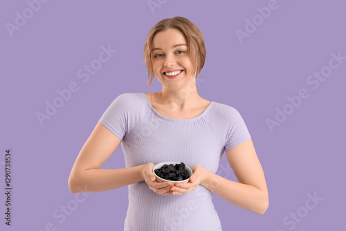 Smiling young woman holding...
