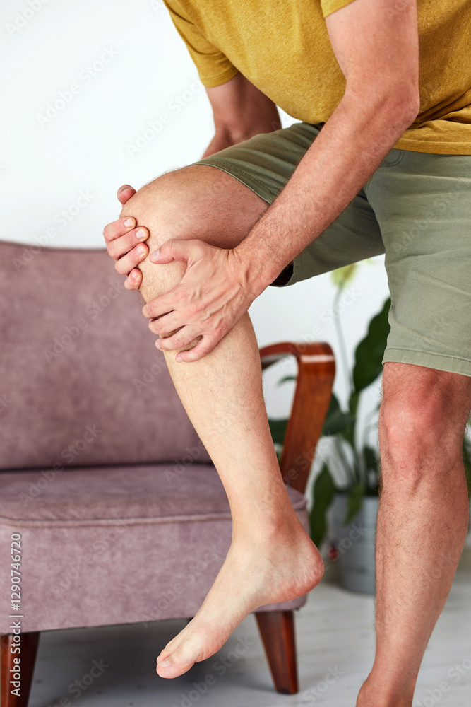 Man with painful knee and leg injury at home.
