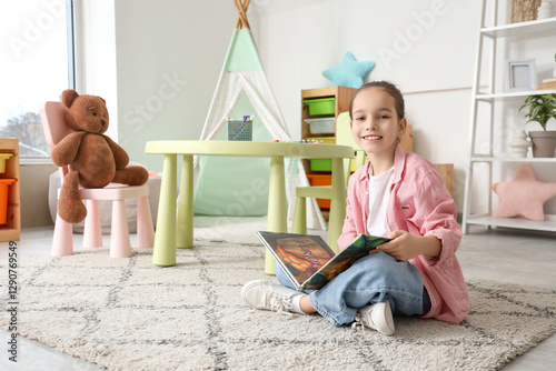 Cute girl reading book on c...