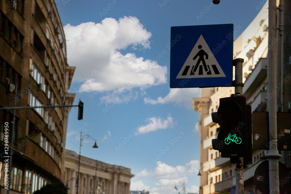 Obraz premium City street at dusk with silhouette of buildings and traffic signs under clear sky near pedestrian crossing