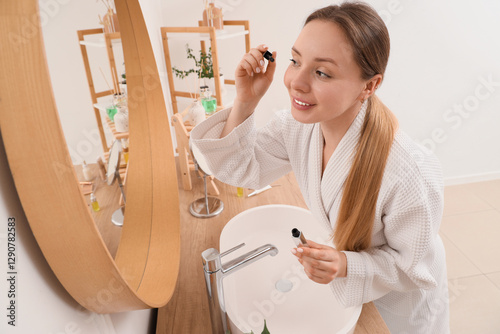 Young woman applying mascar...