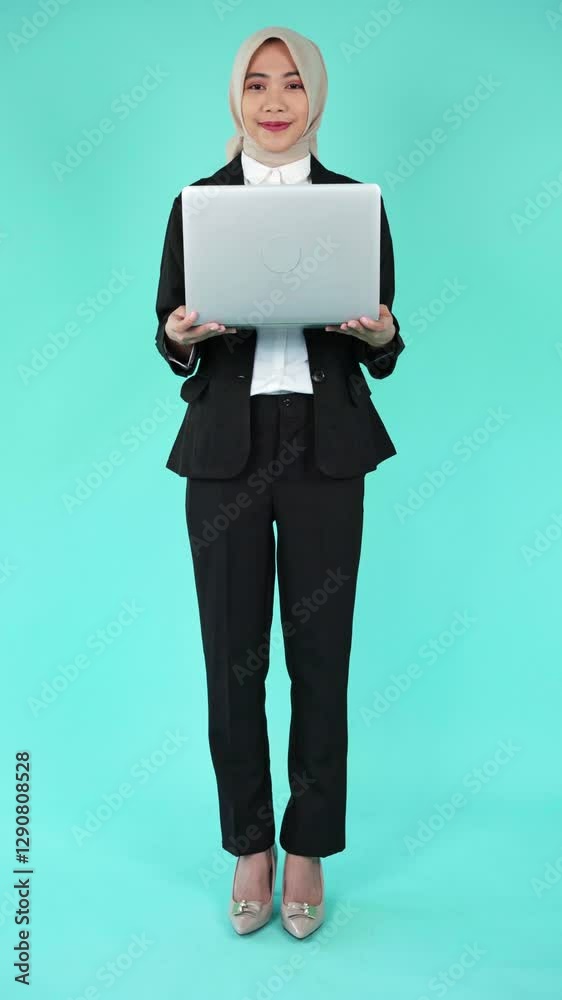 Full Body potrait of Young Woman Office Worker in a hijab Holding Laptop Full Body potrait of Young Woman Office Worker in a hijab Holding Laptop