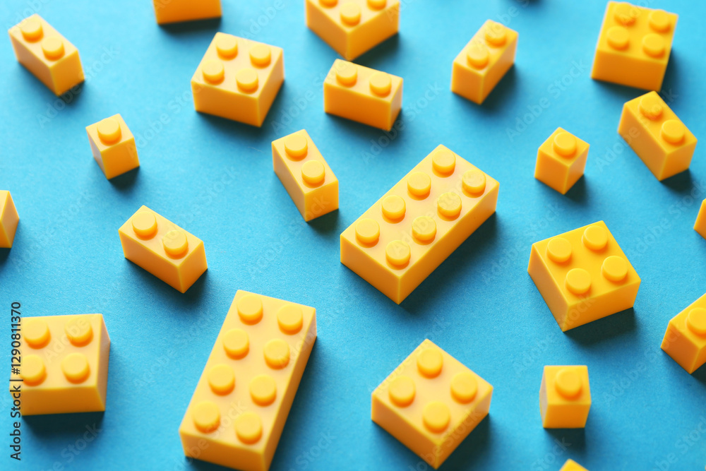 Constructor toy. Many yellow building blocks on light blue background Constructor toy. Many yellow building blocks on light blue background