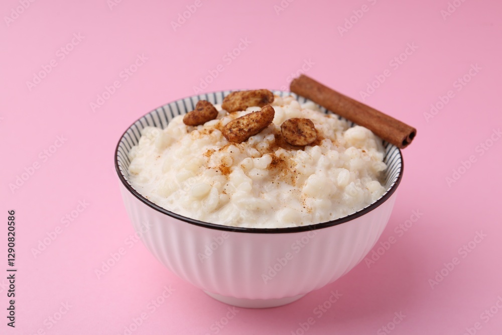 Delicious rice pudding with cinnamon and cashew nuts on pink background, closeup Delicious rice pudding with cinnamon and cashew nuts on pink background, closeup