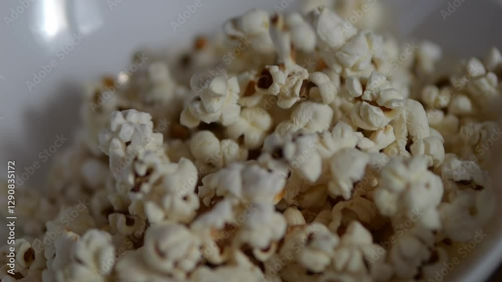 Popcorn falling into a plate. Freshly made popcorn from corn close-up. Popcorn falling into a plate. Freshly made popcorn from corn close-up.