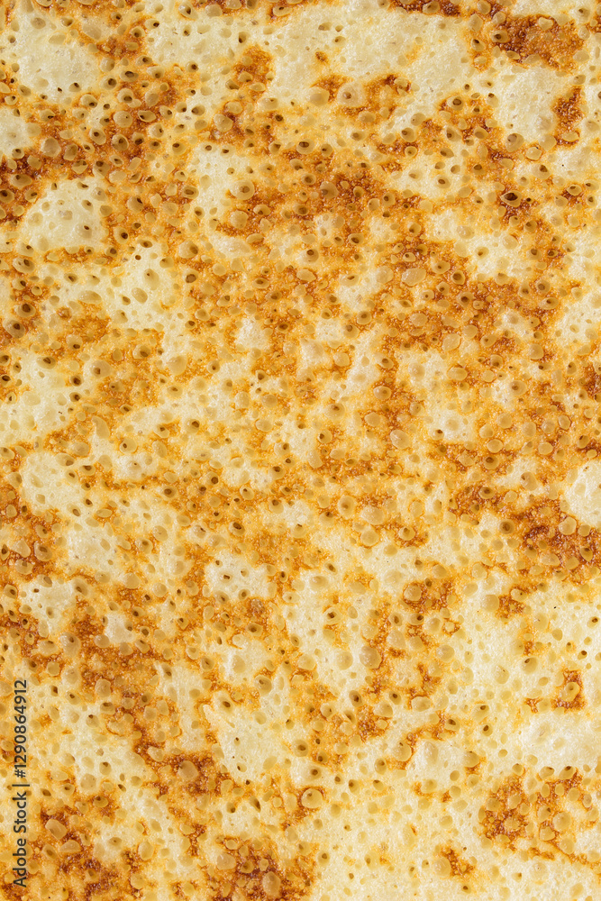 Close-up of a fried pancake or blin with holes for Maslenitsa or Shrovetide. Traditional Russian holiday dish for a feast. Macro photography Close-up of a fried pancake or blin with holes for Maslenitsa or Shrovetide. Traditional Russian holiday dish for a feast. Macro photography