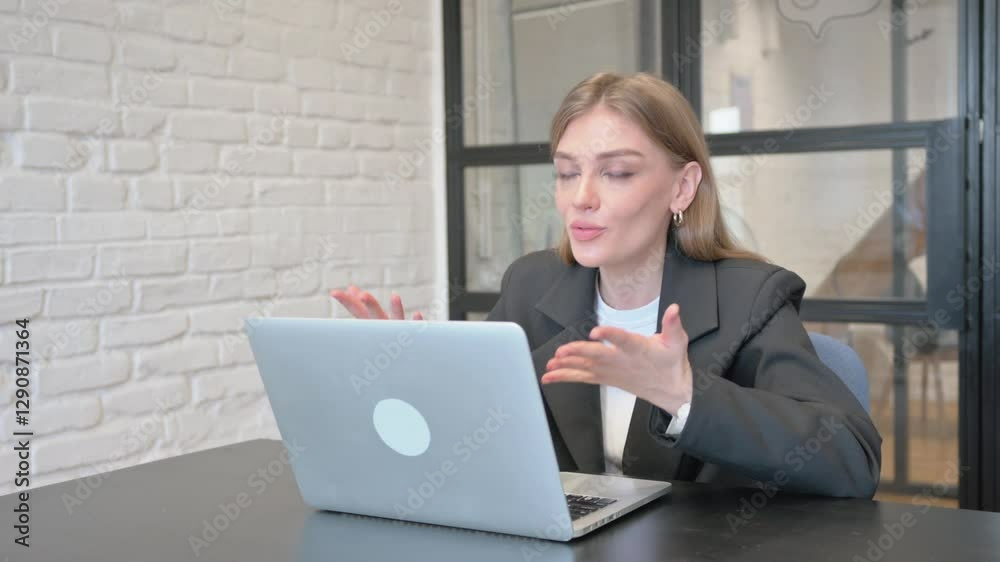 Businesswoman Doing Video Chat via Laptop in Office Businesswoman Doing Video Chat via Laptop in Office